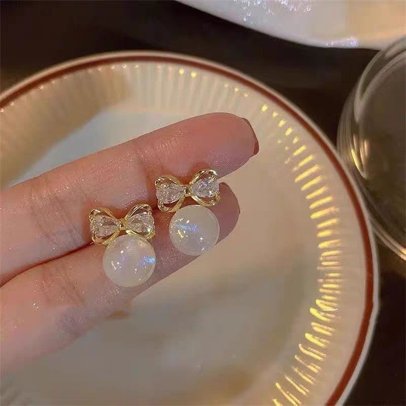 “Elegant bow & moonstone charm ✨—the perfect touch of sparkle for every ear.”
